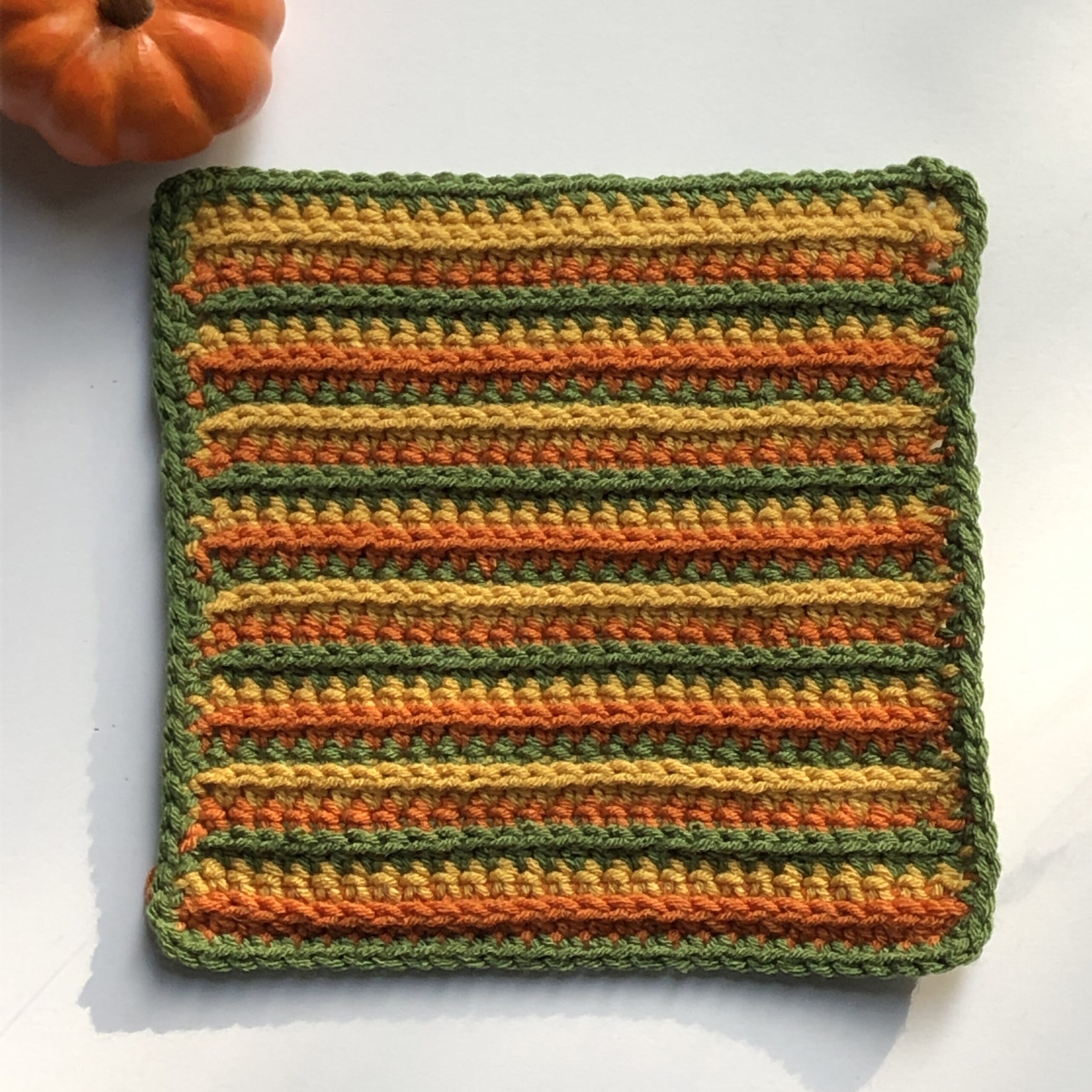 crocheted square with green, orange, and mustard stripes